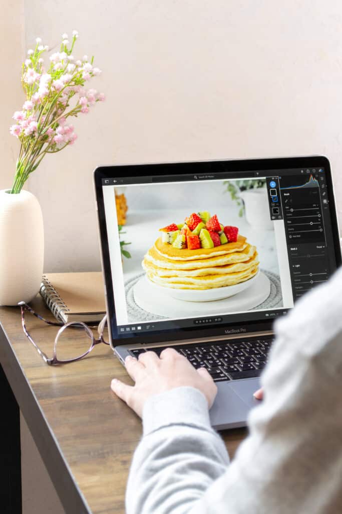 A photo of a food photographer editing a pancake photo