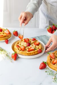 stylist placing Strawberry on waffles