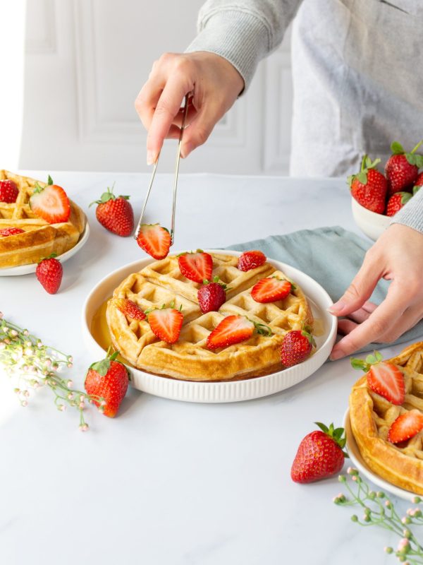 stylist placing Strawberry on waffles